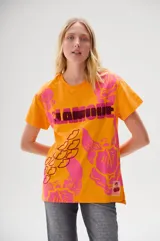 Remera color naranja con estampado floral en tonos rosa y fucsia, con la palabra "LAMODE" en relieve y contorno de labios.