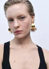 Top negro de tejido de punto fino con corte peplum, cuello de pico, tirantes anchos y espalda descubierta.