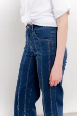 Pantalón de jean azul con corte recto y apliques de strass en líneas verticales.