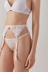 Portaligas blanco de puntilla francesa con motivo floral, con cintura ajustable y tirantes regulables.