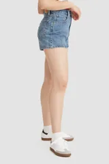 Short de jean de tiro alto color celeste, con bolsillos delanteros y traseros, y ruedo desflecado.
