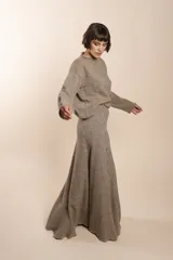 Falda larga color gris con finas rayas verticales, de corte acampanado y cintura alta.