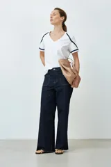 Remera blanca de algodón con escote en V y detalle de vainillas en mangas y hombros.