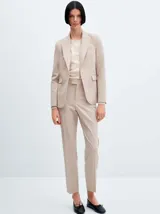 Pantalón de vestir color beige, de corte recto y entallado, con pinzas delanteras, bolsillos laterales y cierre invisible.