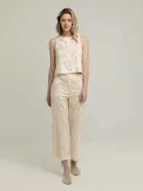 Pantalón negro con estampado dorado de motivos geométricos, corte flare y tiro alto.