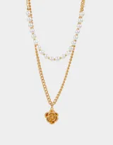 Collar corto dorado de doble cadena, una de perlas y otra de eslabones gruesos, con dije de flor.