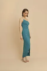 Vestido de fiesta midi color verde petróleo, con breteles finos de strass, corte ajustado y tajo lateral.