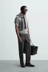 Pantalón chino de vestir negro, corte slim fit, con bolsillos laterales y traseros. Cierre frontal con cremallera y botón.