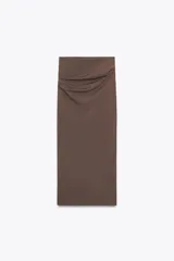 Falda midi color crema, de tiro alto con cintura elástica y detalle de pliegues laterales.
