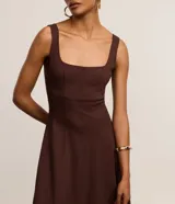 Vestido evasé midi color marrón chocolate, sin mangas, con breteles medianos, escote cuadrado y recortes verticales. Confeccionado en viscosa certificada.