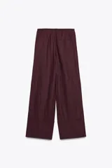 Pantalón palazzo color ladrillo confeccionado en lino 100%. Tiro medio, cintura ajustable con cordones, bolsillos laterales ocultos en costura y pierna ancha.