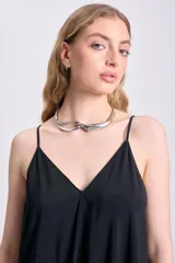 Vestido largo negro con breteles finos y escote en V, de corte amplio y estilo minimalista.