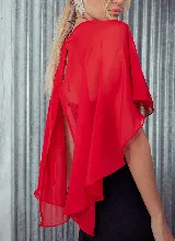 Capa corta color verde esmeralda de gasa transparente, con cuello redondo y abertura frontal con cierre de botón.