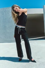 Pantalón ancho gris con textura de espiga, tiro alto, doble cintura elástica ajustable con cordón, pinzas frontales, bolsillos delanteros y falso bolsillo de vivo en la espalda.