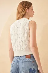 Chaleco de punto color crudo con diseño calado de corazones, sin mangas y con botones joya.