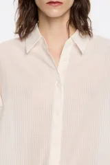 Camisa corta color crema de 100% algodón con cuello camisero y manga corta murciélago. Cierre frontal con botonadura.