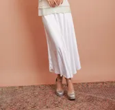 Pollera midi de satén color blanco, de corte evasé.