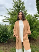 Kimono color camel confeccionado en muselina 100% algodón, con mangas 3/4 y bolsillos frontales.