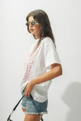 Remera blanca de corte holgado con estampado de círculos rojos.