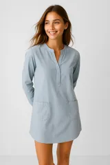 Vestido corto celeste de algodón con cuello mao, escote en V, mangas largas y dos bolsillos frontales.