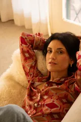 Camisa de manga larga con cuello clásico y botones frontales. Estampado geométrico en tonos naranja, rojo y beige.