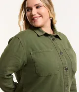 Campera plus size color verde militar, modelo oversized, confeccionada en sarga texturizada. Cuenta con cuello tradicional, cierre abotonado, dos bolsillos delanteros y puños abotonados.