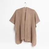 Ruana beige de tejido calado con mangas cortas.