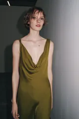 Vestido largo color verde oliva de satén, con escote drapeado y tirantes finos que se atan en la espalda.