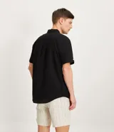 Camisa de hombre de manga corta confeccionada en una mezcla de lino y algodón, marca Marfinno. Presenta un calce confort, cuello clásico, cierre frontal con botones y un bolsillo de parche con solapa en el pecho. Las mangas cuentan con un detalle de dobladillo.