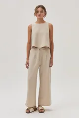 Pantalón de vestir color beige, de corte ancho y tiro alto, con cintura elástica ajustable con cordón.