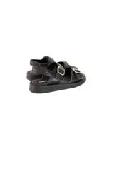 Sandalias planas negras de cuero, con múltiples correas ajustables con hebillas metálicas doradas.