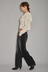 Jean de corte barrel con diseño de pierna curva y holgada, confeccionado en denim negro con efecto lavado. Presenta un estilo moderno y estructurado con costuras laterales marcadas.