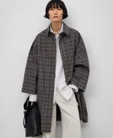 Gabardina larga a cuadros con cuello solapa, manga japonesa y cierre con botones.