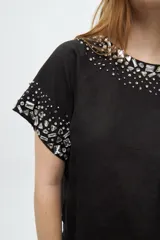 Blusa color crudo de lino y algodón, de manga corta con escote redondo y bordado de lentejuelas y mostacillas en el cuello y mangas.