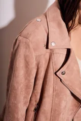 Campera color rosa viejo, estilo motociclista, confeccionada en gamuza sintética con cierre asimétrico y detalles de tachas.