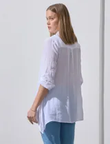 Camisa larga de rayón marca Robert Louis, con estampado a rayas verticales en tonos coral y blanco. Tiene cuello con solapa, abertura central con botones, mangas largas regulables con presilla y botón, y tajos laterales.