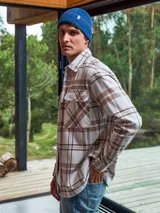 Sobrecamisa a cuadros color crema, marrón y blanco, de manga larga con cierre de botones y bolsillos en el pecho.