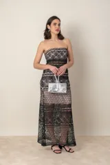 Vestido largo de fiesta negro con forro color nude y encaje calado con motivos geométricos. Diseño strapless con transparencia en cintura y ruedo.
