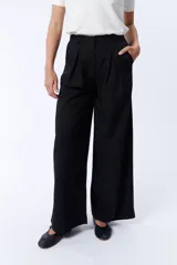 Pantalón de vestir negro de corte palazzo con pinzas en la cintura y bolsillos laterales.