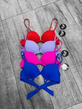 Corpiño de bikini con aro y moldeado, con tirantes finos ajustables. Se muestra en cuatro colores: rojo, lila, fucsia y azul eléctrico.