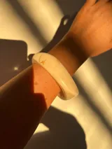 Brazalete rígido de acrílico color blanco con forma irregular.