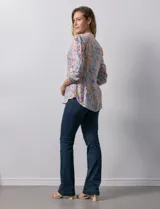 Blusa de gasa estampada con cuello a la base, escote en V y botones. Delantera con detalle plisado y largo de manga regulable con presilla y botón.