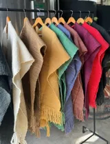 Ruana de lana merino tejida en telares manuales, disponible en varios colores.