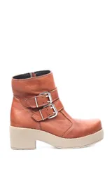 Bota corta color marrón de cuero liso, con caña baja, base beige y dos correas con hebillas plateadas.