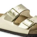 Sandalias de cuero color dorado con doble cinta y hebillas ajustables.