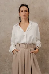 Camisa negra de manga larga con botones, cuello clásico y corte holgado.