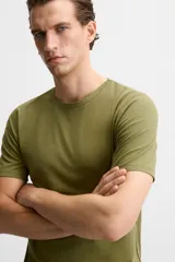 Camiseta slim fit de cuello redondo y manga corta, confeccionada en tejido de algodón con elasticidad.