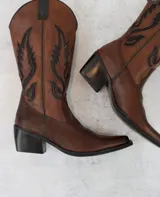 Bota texana de cuero color marrón con bordados negros en el lateral.