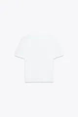 Camiseta blanca de manga corta y cuello redondo. Estampado frontal con etiqueta negra y dorada.