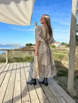 Vestido largo de seda con estampado geométrico en tonos beige, negro y marrón.